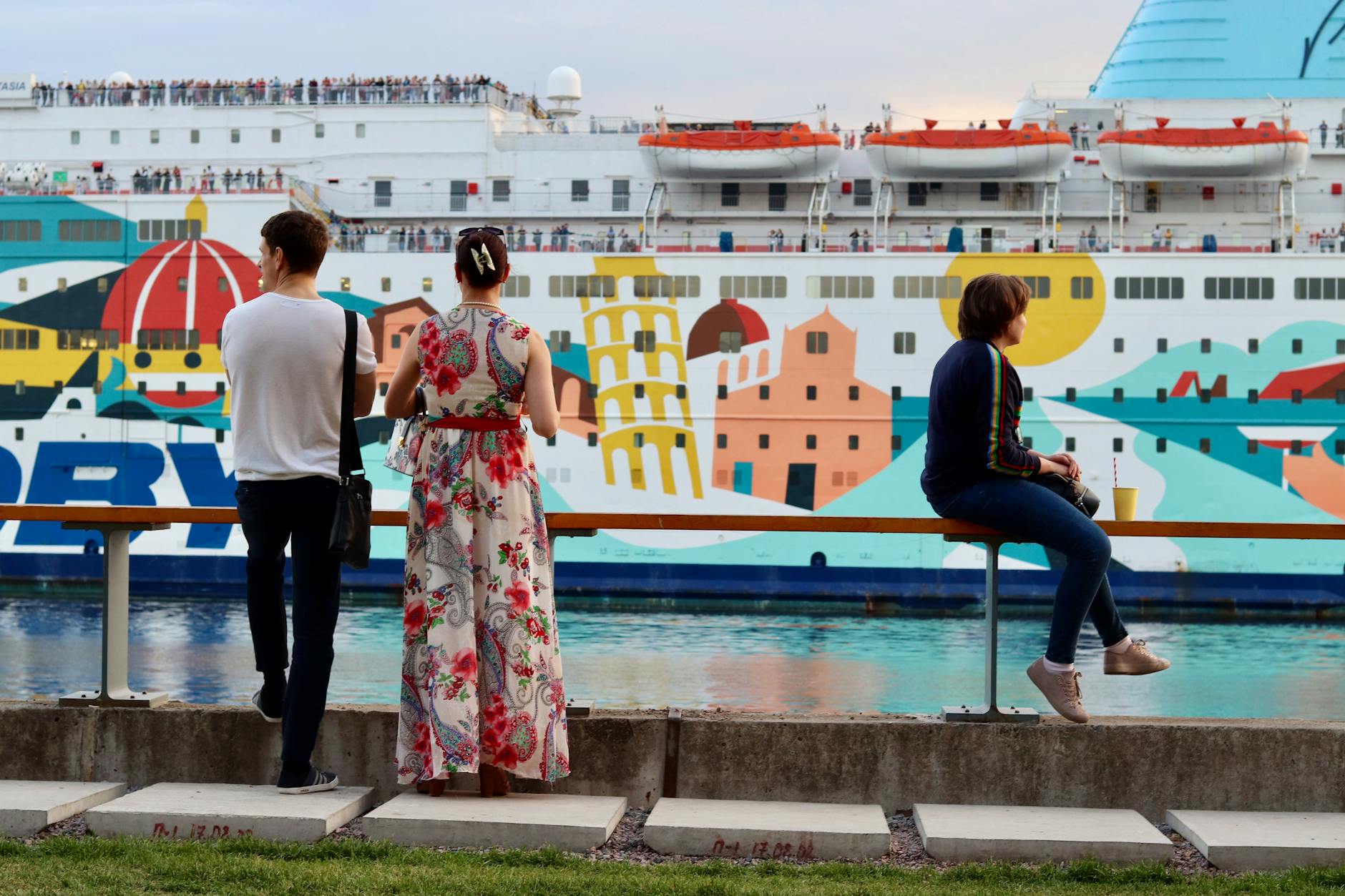 people standing by the metal railing in front of cruise ship