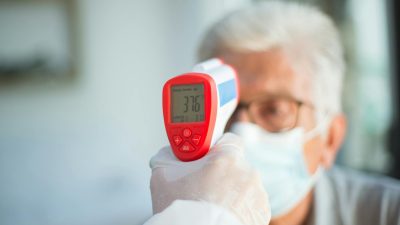 man during thermometer medical exam