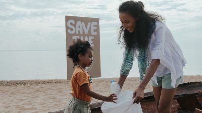 two women cleaning at the beach