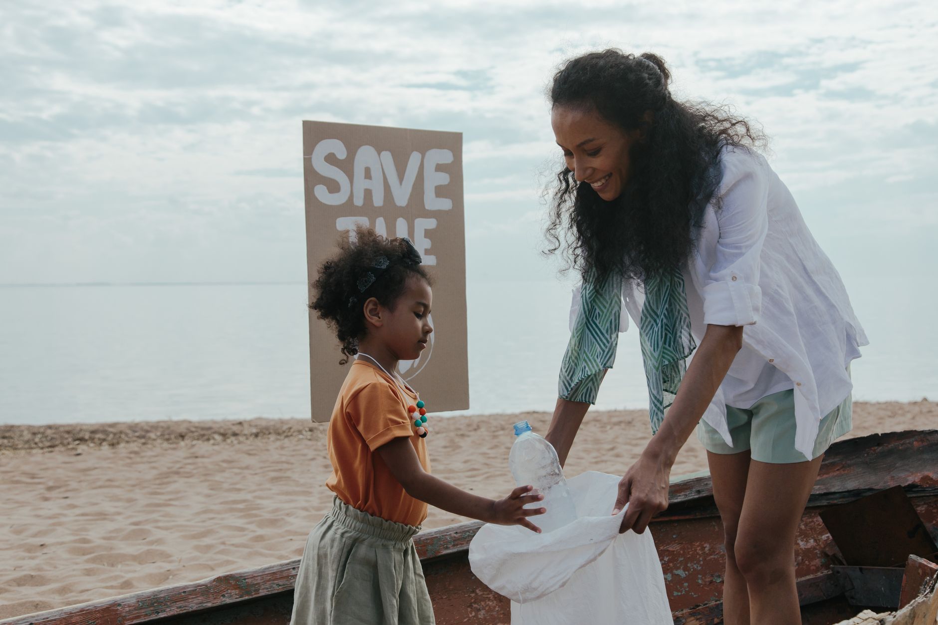 two women cleaning at the beach