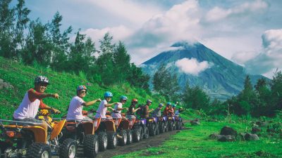 line of men riding on all terrain vehicles holding out hand in a fist