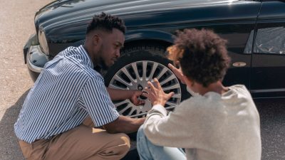 man in white and black stripe dress shirt sitting on car