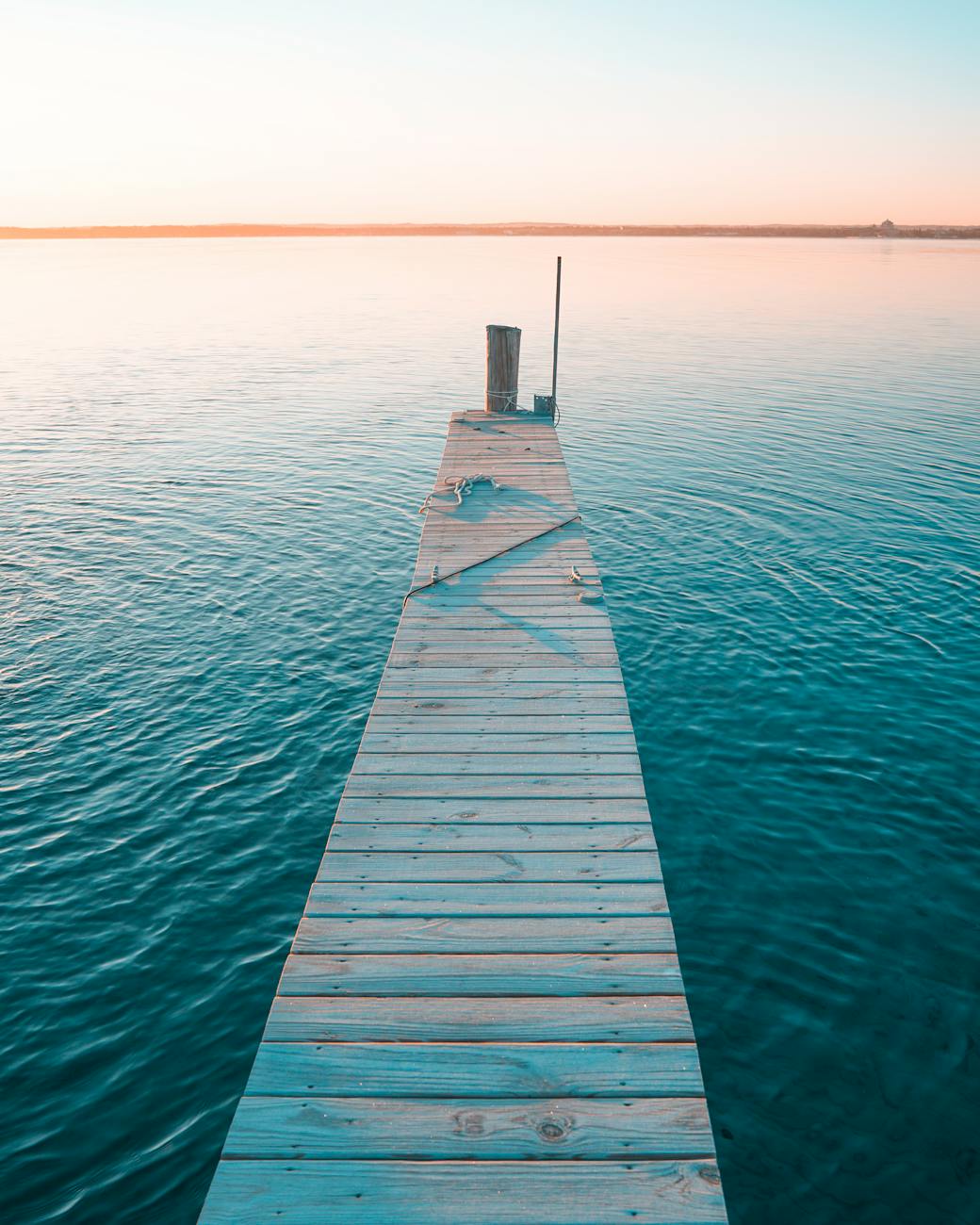 wooden pier on a lake at sunset