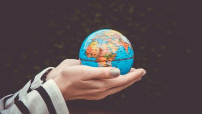 person holding blue mini globe