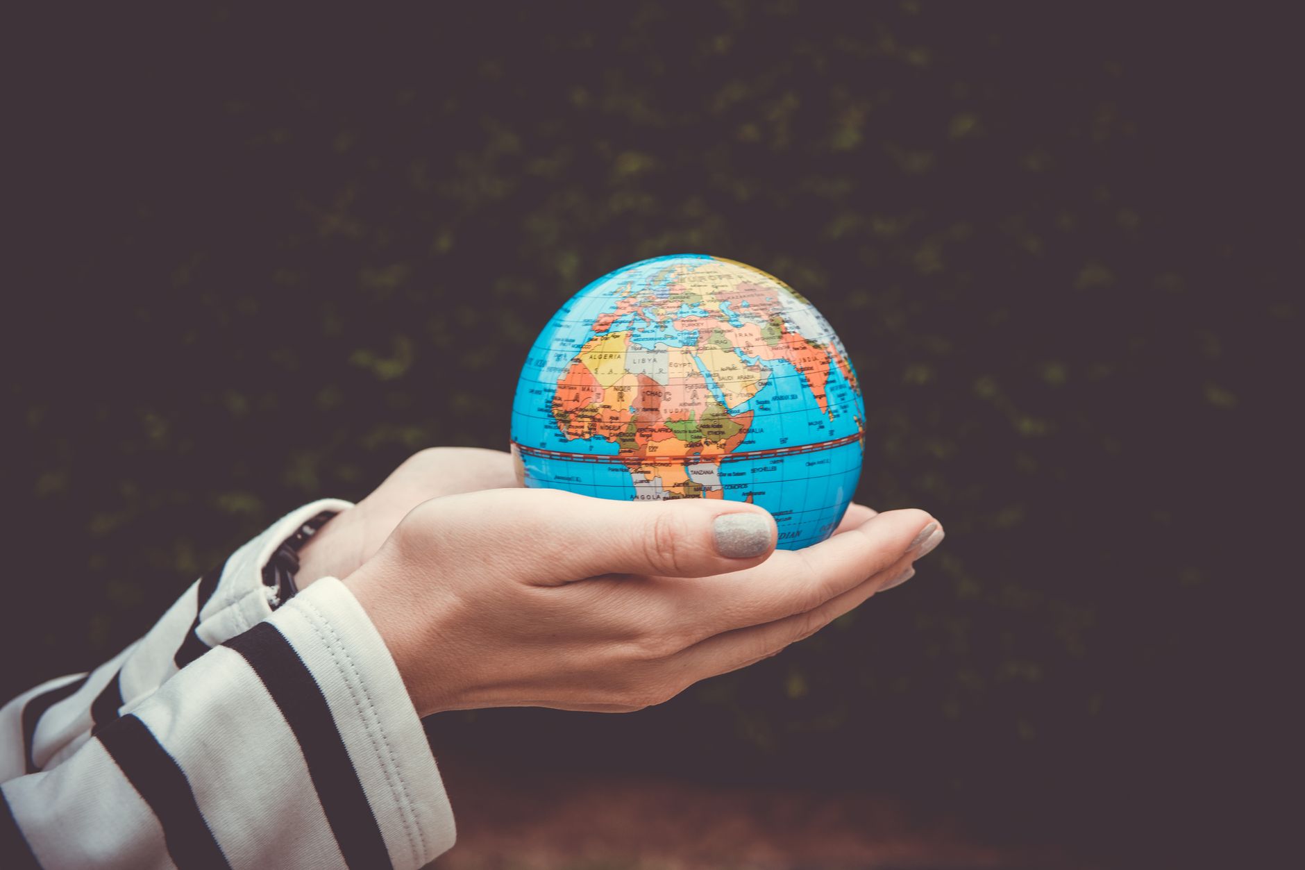 person holding blue mini globe