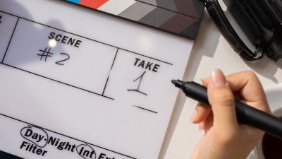 woman writing on clapperboard