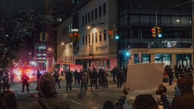 demonstrators with protest signs facing police officers